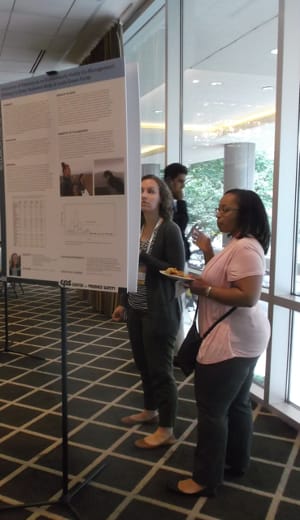 Amy Kahler, left, and Candace Miller, water researchers with the Centers for Disease Control and Prevention, look over one of the many research-project posters on display at the symposium.