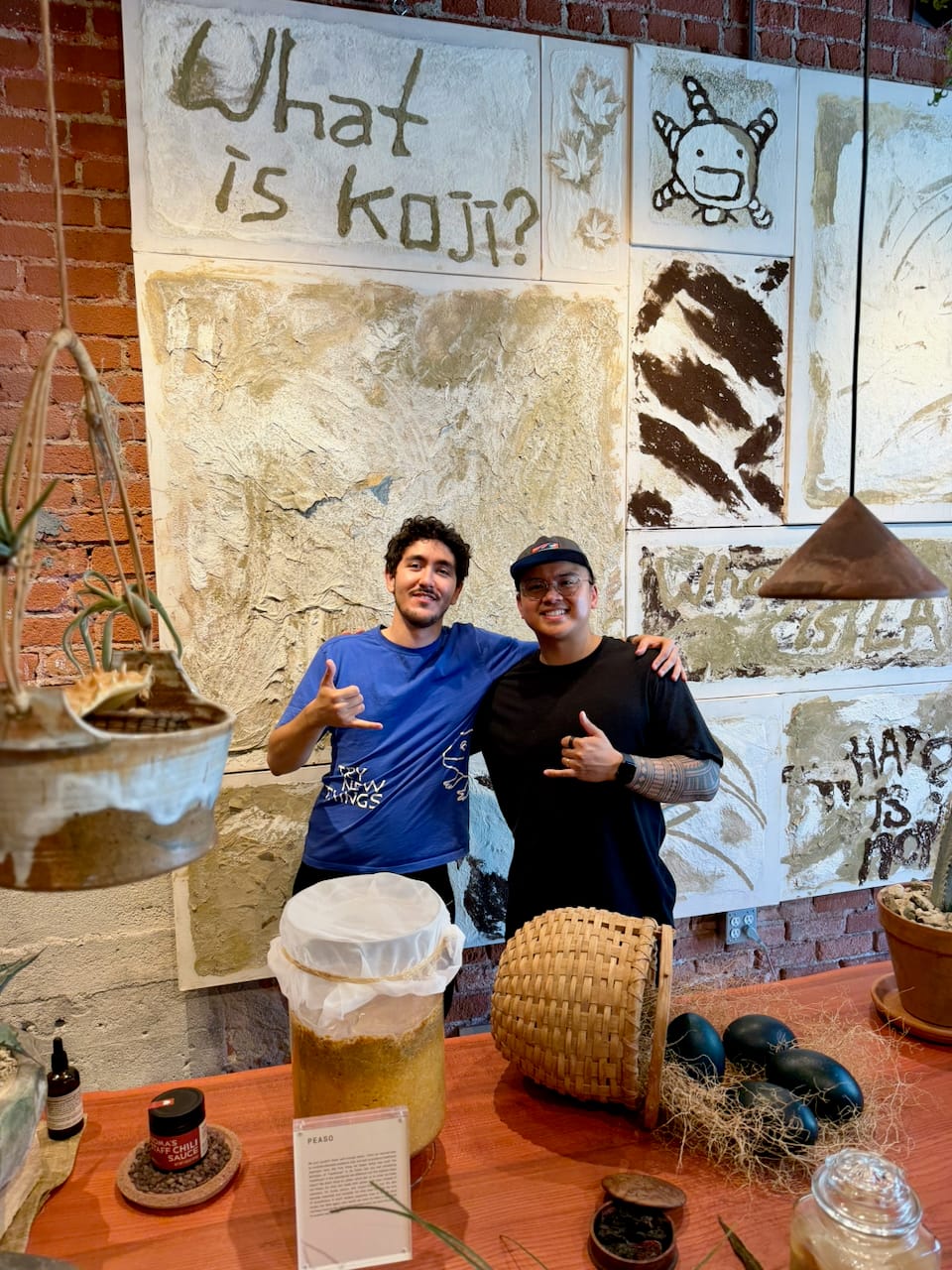 Geronimo Ramos and Nico at Noma Projects Silver Lake store in front of What is Koji art wall