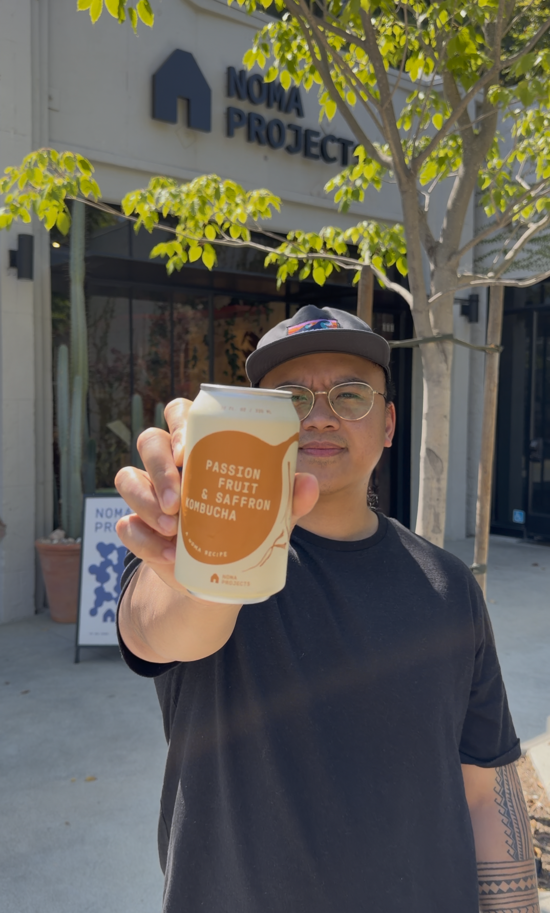 Geronimo Ramos holding Passion Fruit and Saffron Fermensch Kombucha outside Noma Projects Silver Lake