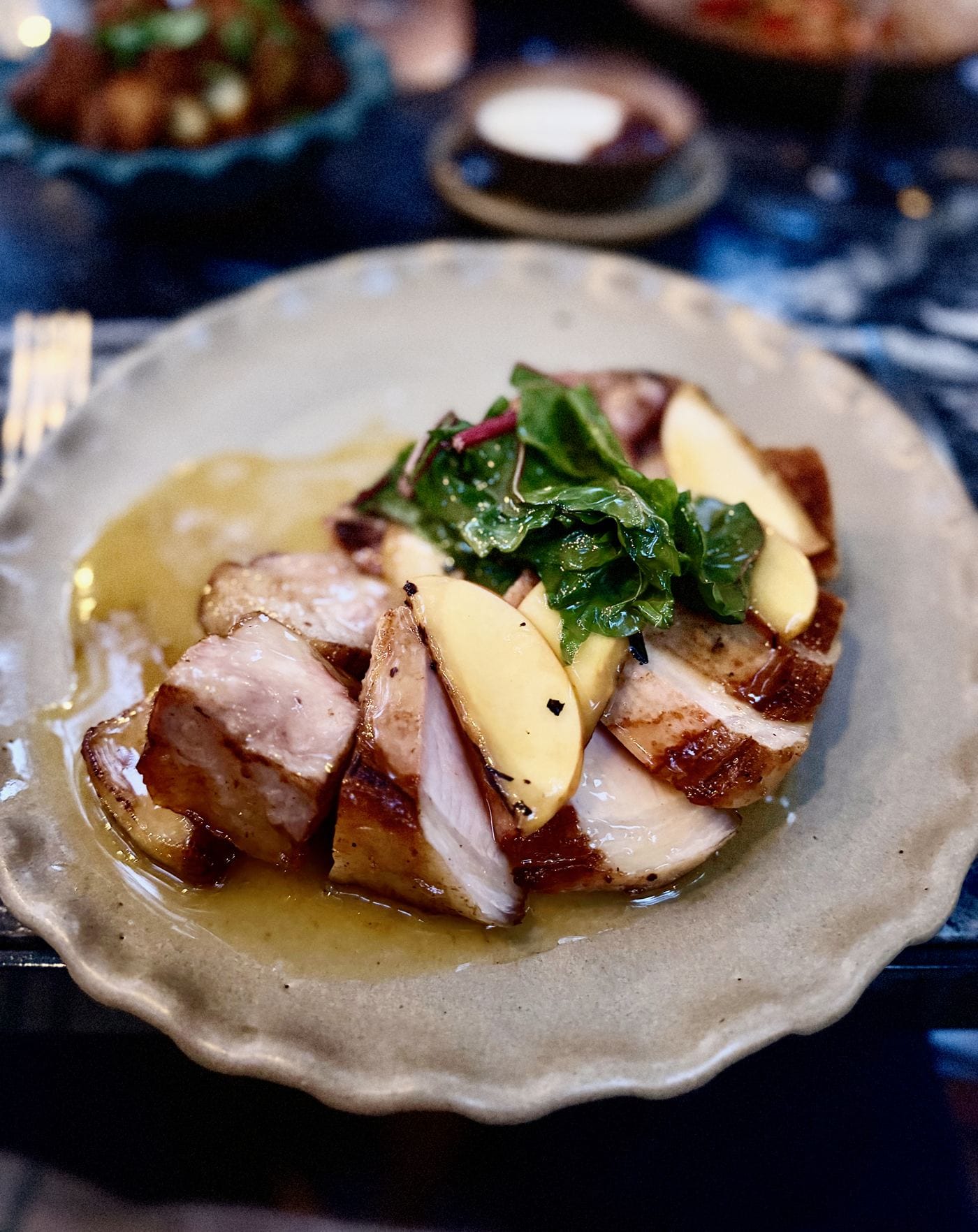 Pork chop with coal-roasted apple and greens at Little Mountain restaurant in Montecito