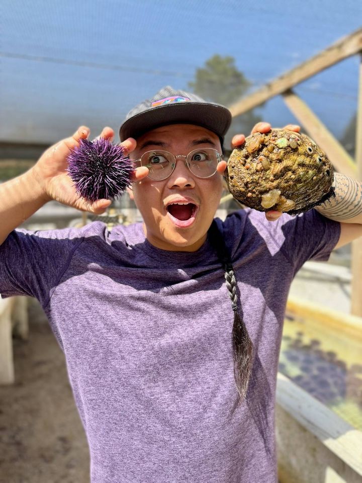 Geronimo Ramos holding a purple sea urchin and red abalone at the Cultured Abalone Farm in Goleta California