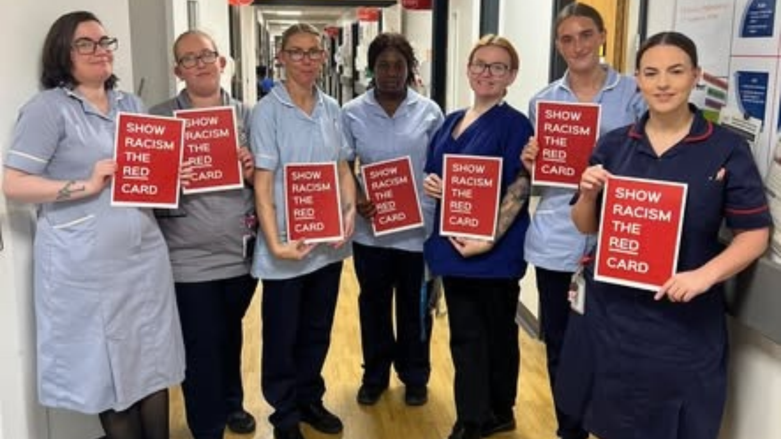 WUTH and WCHC staff wearing the red racism cards in a group display against racism.
