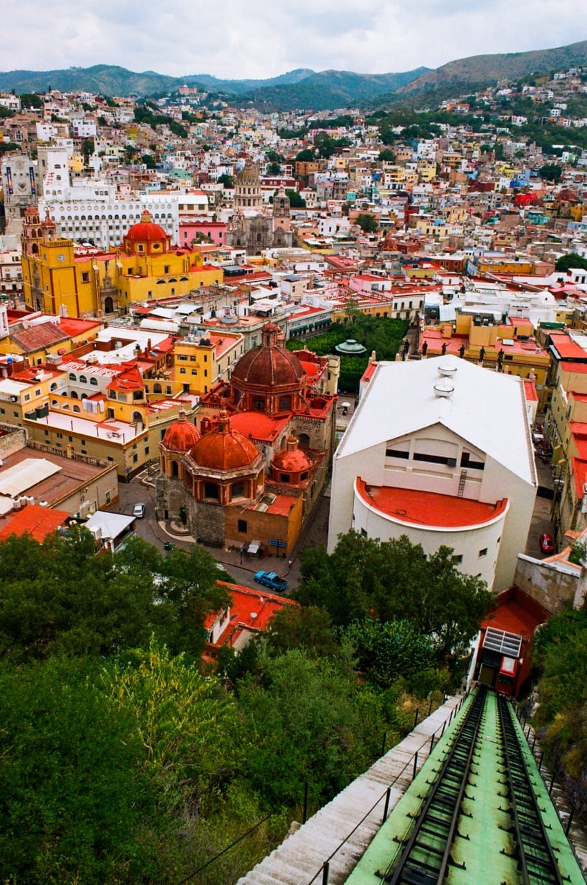 a color photo of the City of Guanajuato, viewed from the funicular to El Pípila. The funicular tracks are in the foreground.