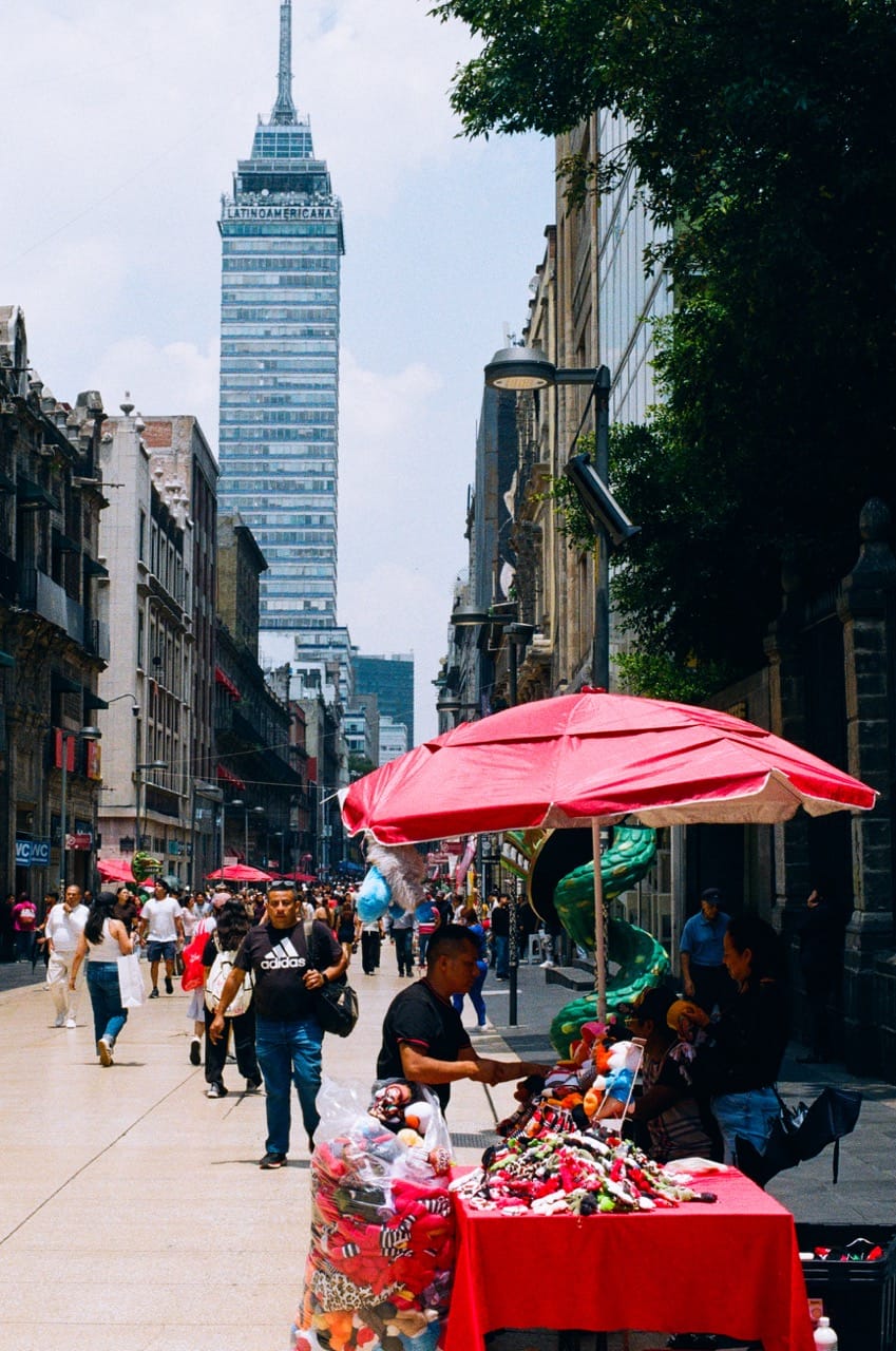 a photo of the Torre Latinoamerica in the background, with a street vendor in the foreground