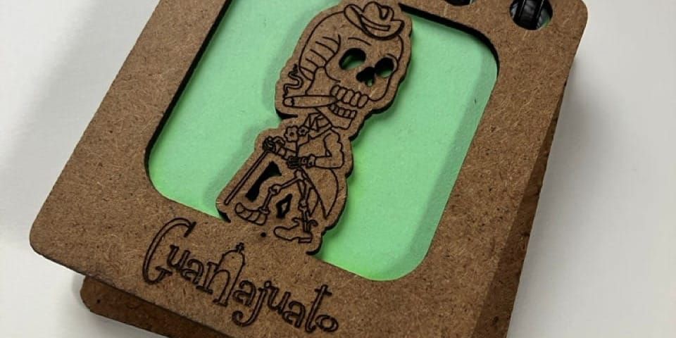 a close-up of a souvenier notebook from Guanajuato featuring a cheeky skeleton smoking a cigar on the cover