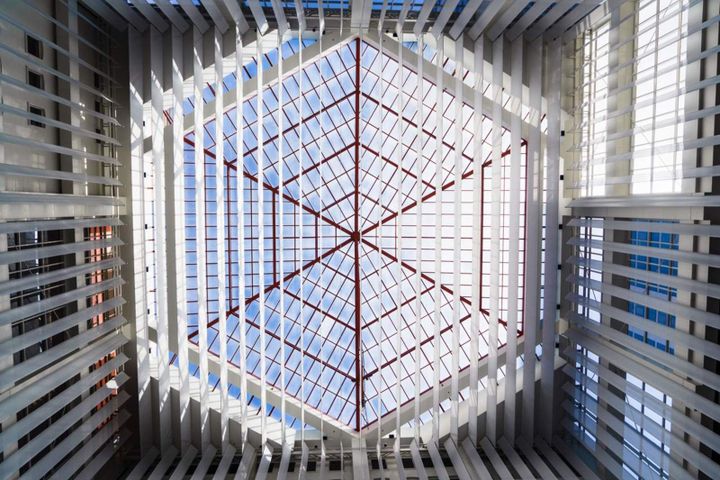 Geometric glass atrium ceiling with structural grid, representing enterprise AI data connectivity and system integration