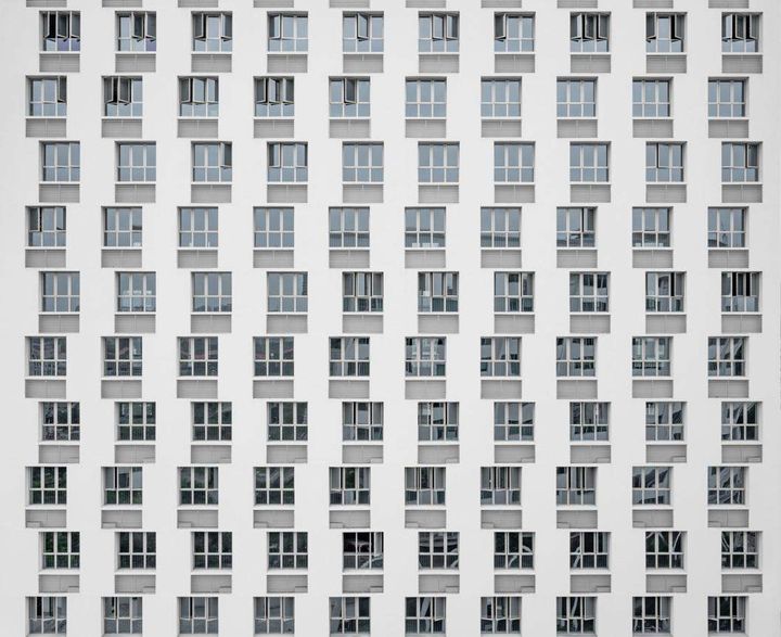 Uniform grid of windows on a modern building facade, representing standardised per-unit pricing shifting toward usage-based enterprise AI cost models.