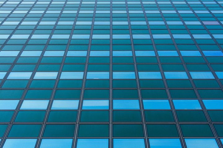lue glass corporate building facade with uniform grid pattern, representing structured enterprise process design