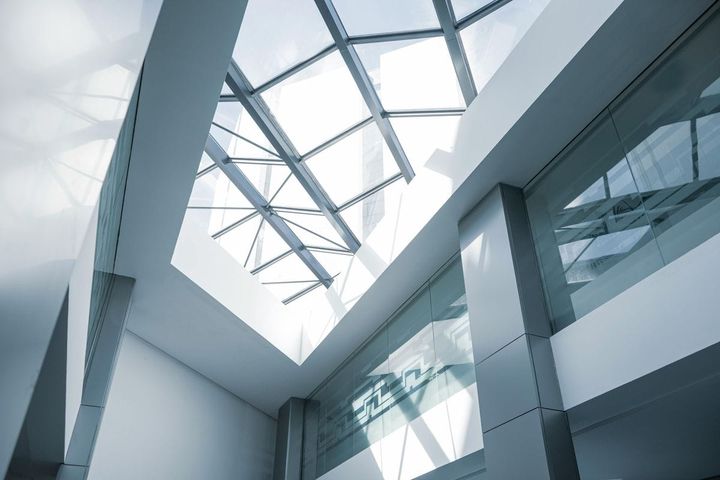 Modern corporate building interior with glass skylight and steel framework, representing enterprise-scale operational infrastructure