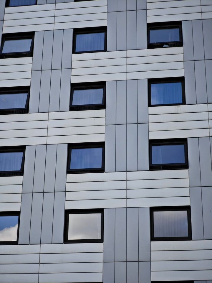 Modern office building facade with geometric windows and clean architectural lines, representing enterprise technology infrastructure, data centres and AI data residency.