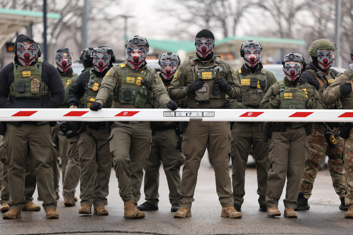 A photo of border patrol officers in military getup, each with a clown face transparently transposed over their own.