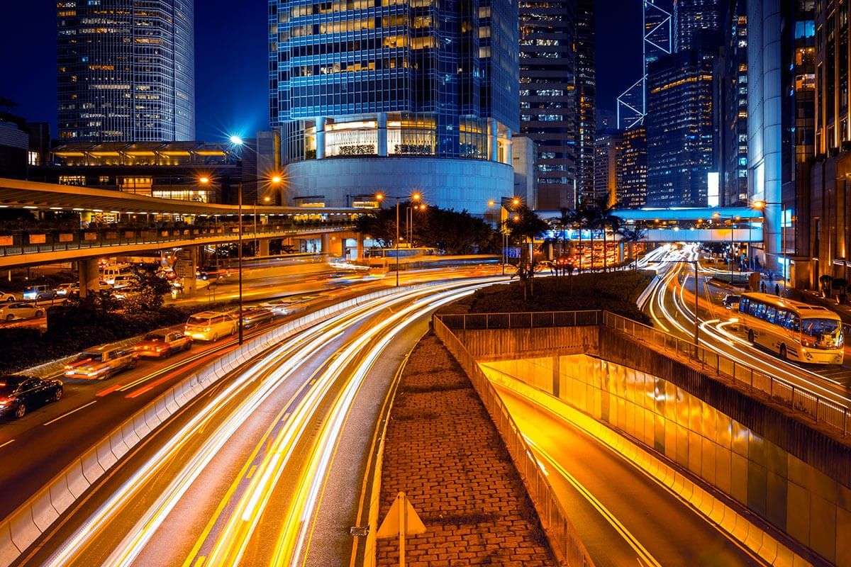 Night city skyline with long-exposure light trails, symbolizing acceleration in the age of AI and the search for clarity.