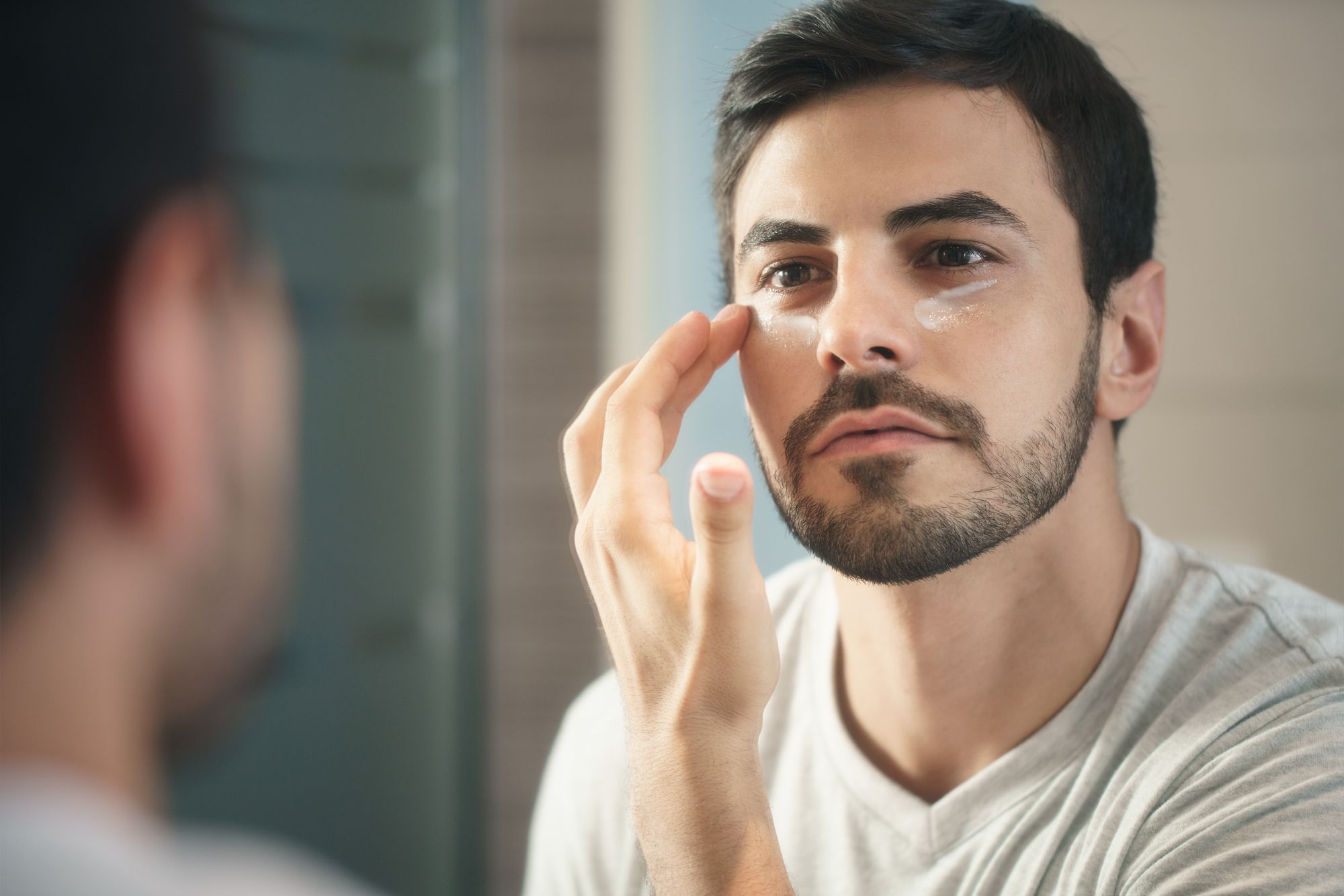 Joven aplicando crema antiedad como parte de su rutina de cuidado personal