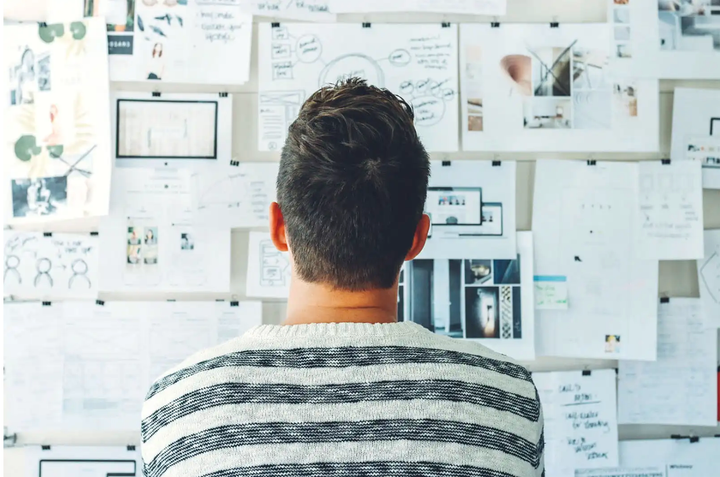 Hombre mirando un panel con muchos diseños