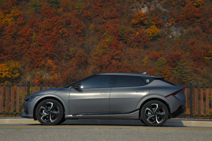 Kia EV6 estacionado junto a hojas de otoño.