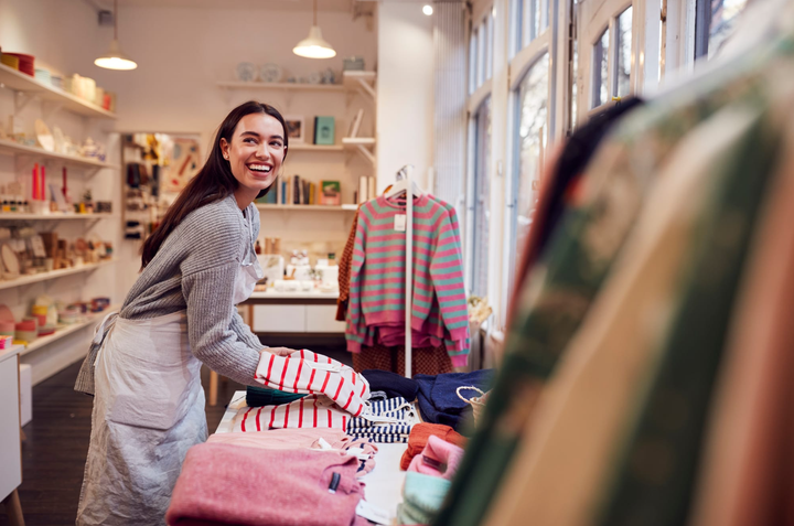 Propietaria de una pequeña empresa organizando productos en el escaparate