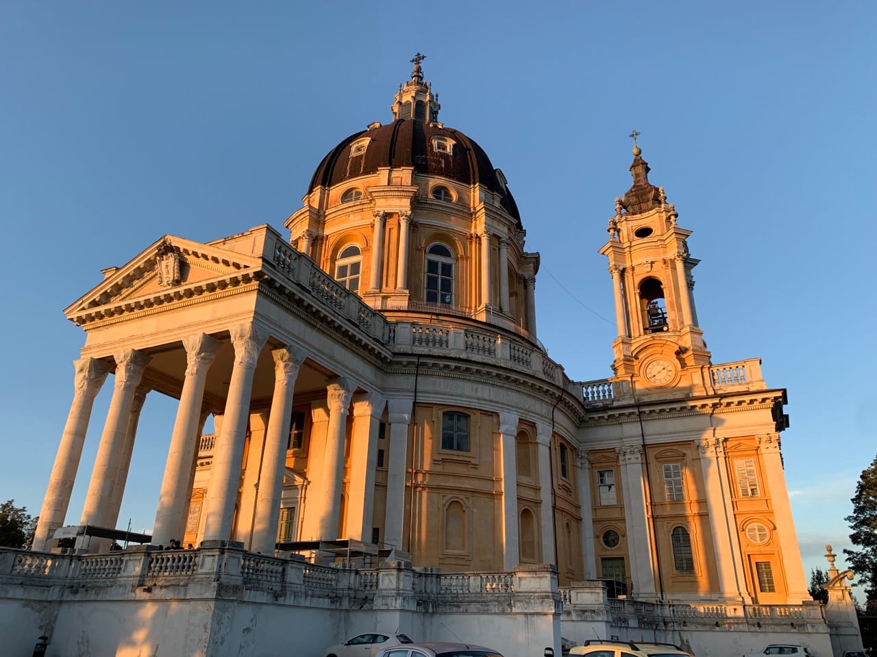 A large baroque church against a blue sky at sunset.