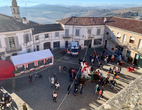 Families playing traditional wooden games in the piazza at Govone.