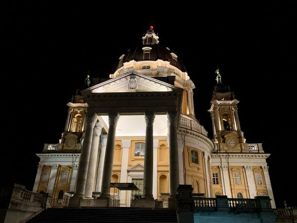 A large baroque church illuminated against a black sky