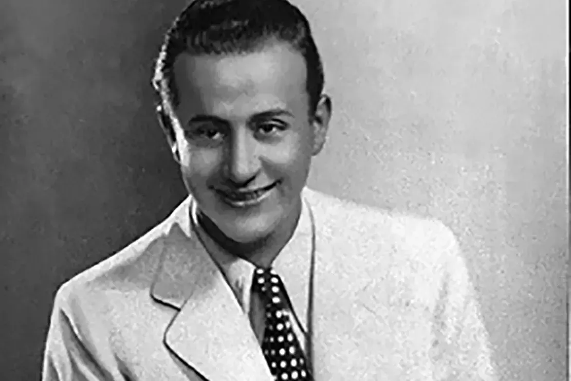 Singer Charlo in white suit and dotted tie