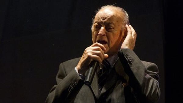 Singer Juan Carlos Godoy in a suit in black background