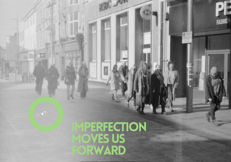 A black adn white photo of Dudley People’s School for Climate Justice partners walking together on the High Street with the words ‘Imperfection moves us forward’