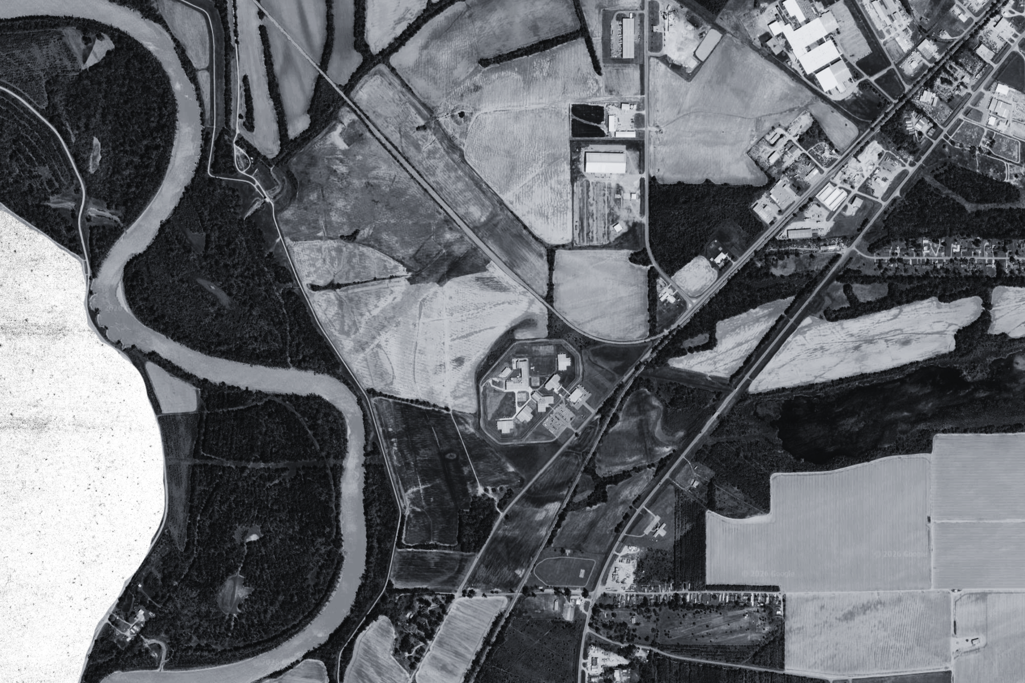 A prison next to two country roads and a river.