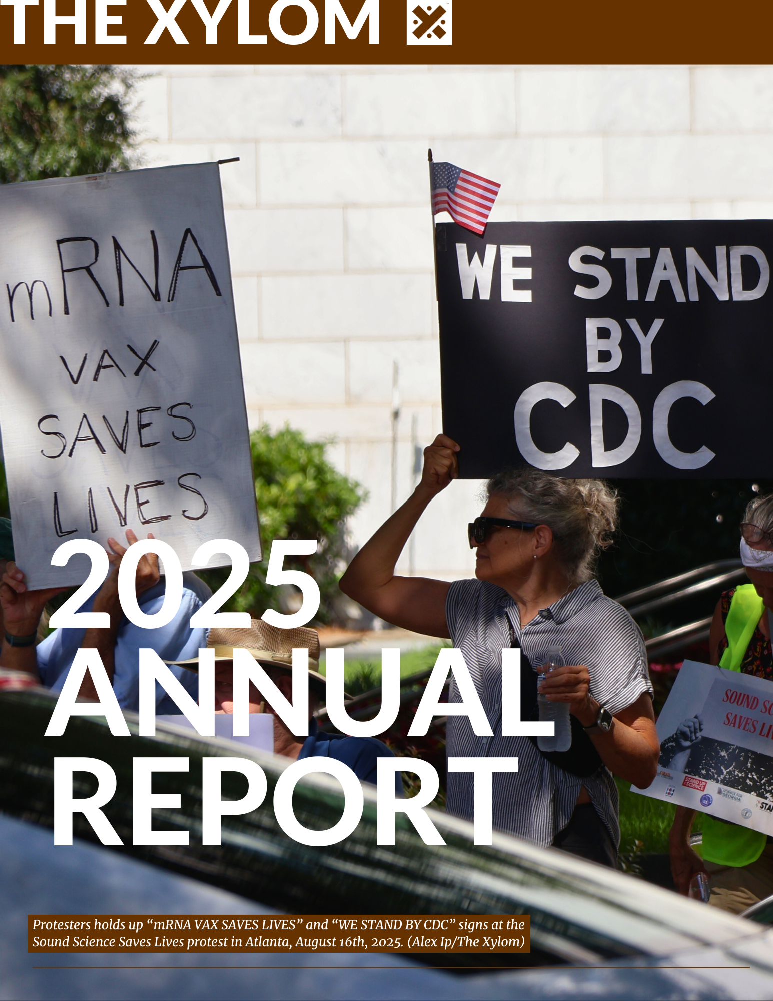 Protesters holds up “mRNA VAX SAVES LIVES” and “WE STAND BY CDC” signs at the Sound Science Saves Lives protest in Atlanta