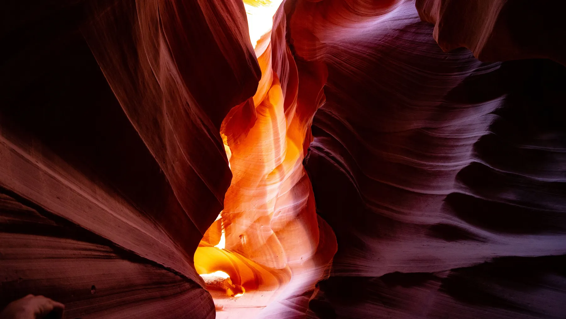 A narrow canyon looks bright with sunlight from the top.