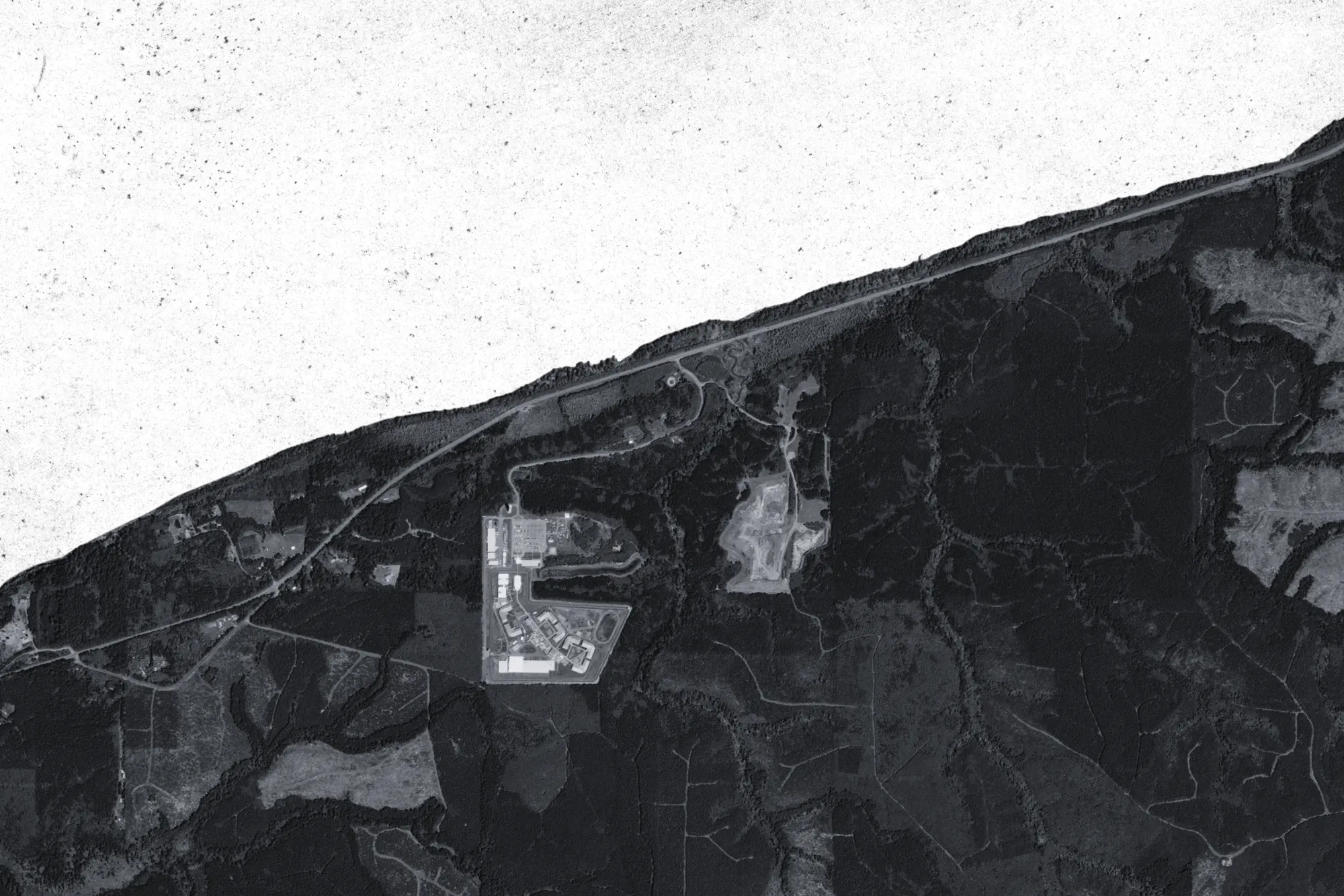 A prison next to the shore, surrounded by wilderness.
