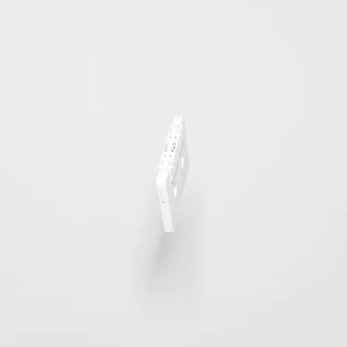 A white coloured casette is seen on a plain white wall. 