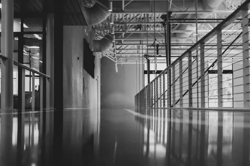 A black-and-white shot of a hallway of a modern building. 