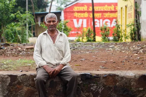 An Indian man sits in his neighborhood