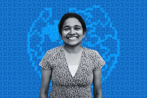 Netha Hussain, an Indian woman, in front of a stylized blue puzzle globe background