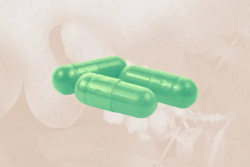 Three green pills on a beige background.