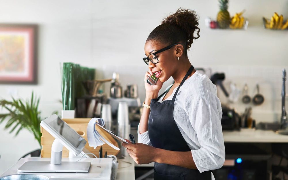 mulher negra de óculos chefiando um restaurante