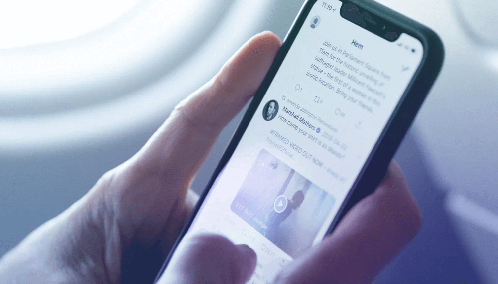 detalhe de mão segurando um celular com a tela aberta na plataforma Twitter
