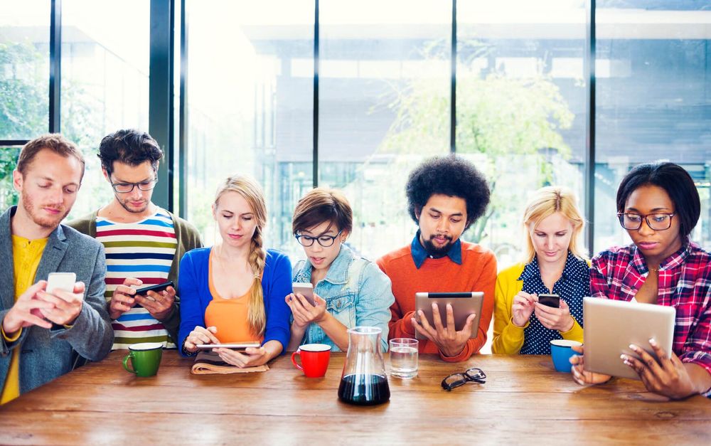 grupo de jovens reunidos no que parece ser um debate para alinhar estratégias para redes sociais