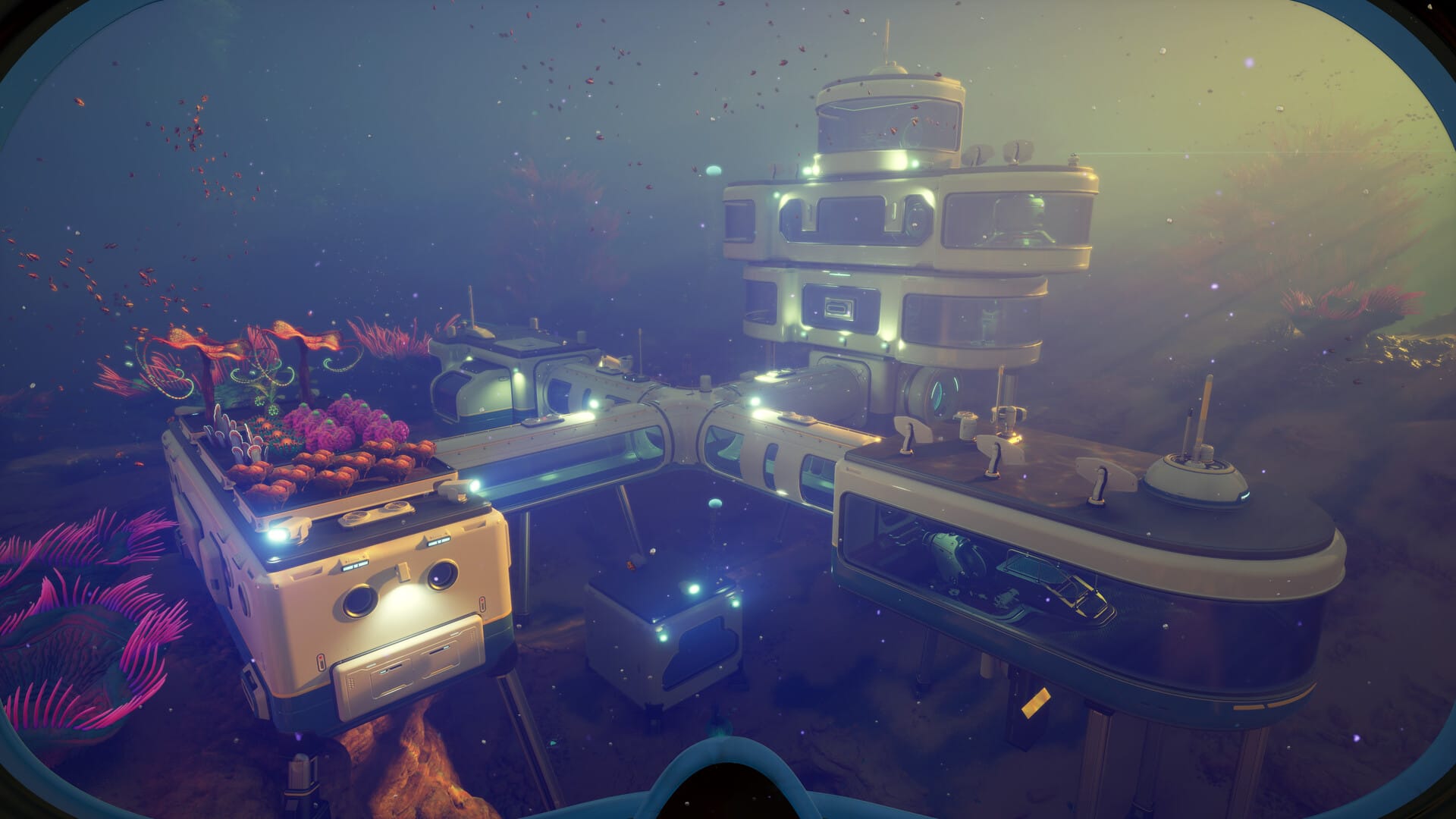 A sleek underwater base surrounded by marine life and lit by exterior floods.