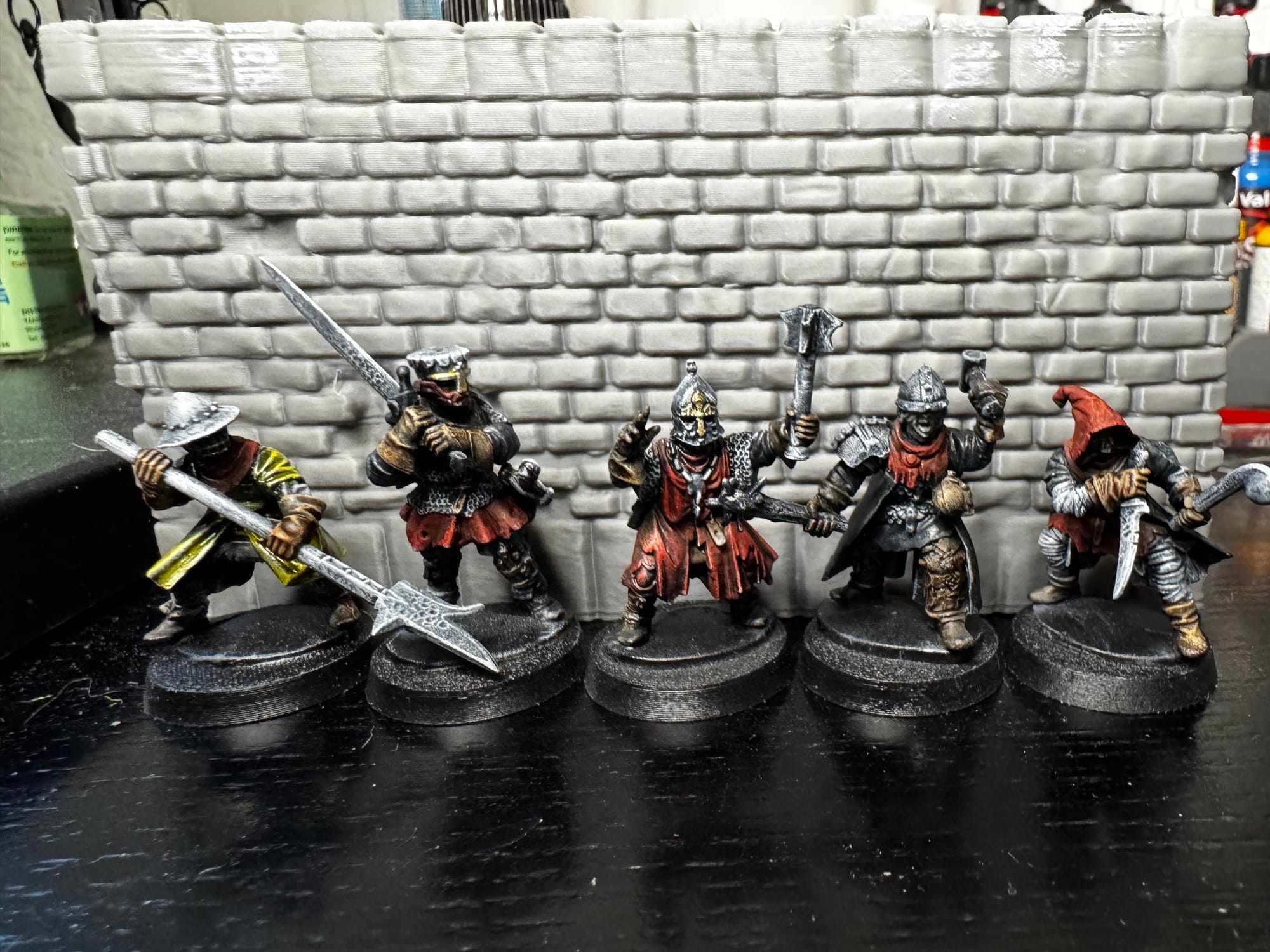Carefully-painted 3D-printed miniatures of medieval fantasy unit archetypes sporting oversized weapons and nasty-looking metal armor.