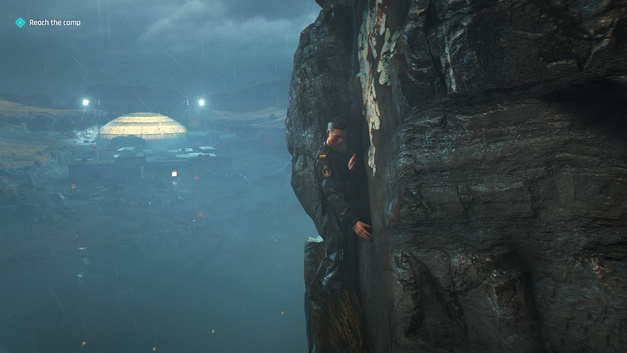 Bond, in his airman's uniform, clings to the edge of a cliff.