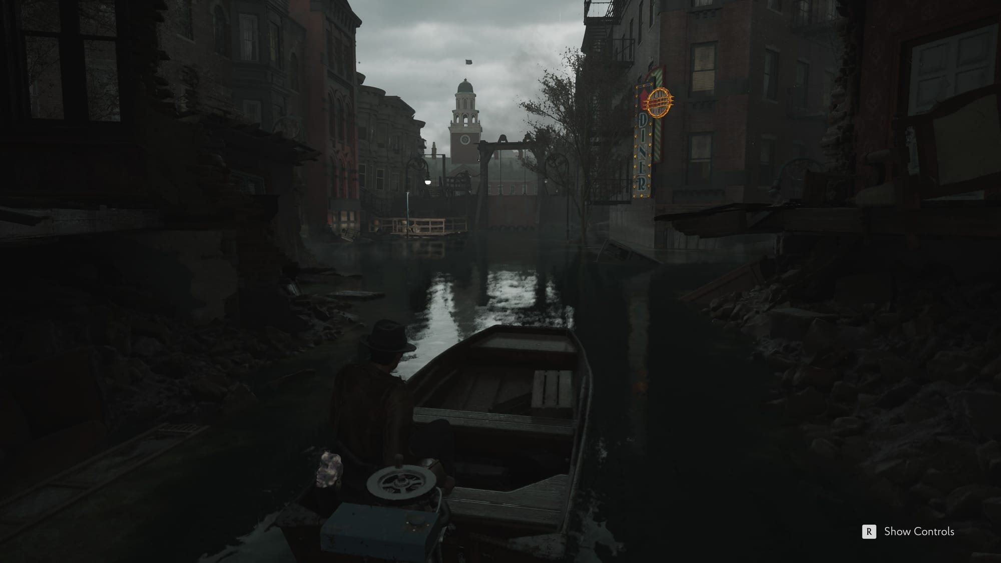 A man in a brown jacket and hat pilots a launch down a sludgy canal.
