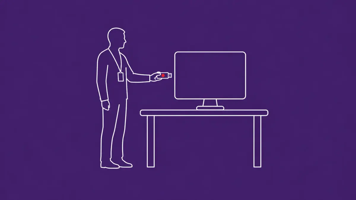 Line-art office desk with a desktop monitor and a person silhouette beside it holding a small USB drive icon; the USB drive carries a red dot.