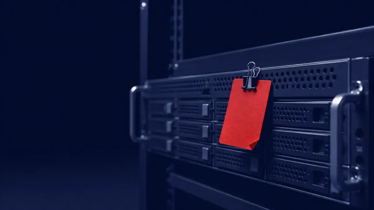 Navy duotone documentary: an RMM server rack with one red warning tag — CISA adds the exploited N-able N-central flaw CVE-2026-18577 to its KEV catalog.