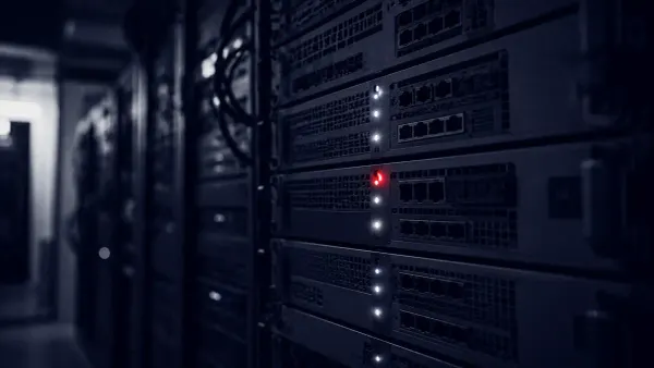 A vector illustration of a shield deflecting a Medusa-head motif over a network of servers, with one flat red alert dot, representing the updated CISA, FBI and HHS ransomware advisory.