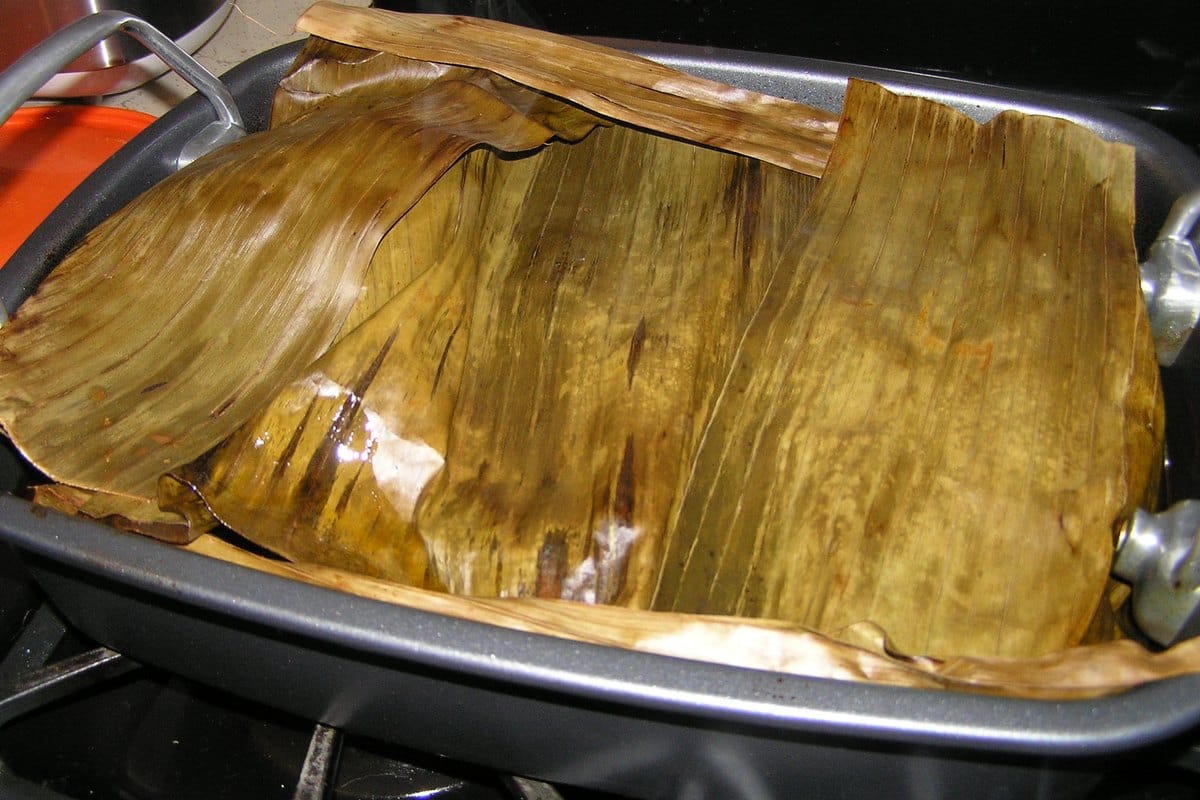 Banana leaves lining a roasting pan for puerco pibil.