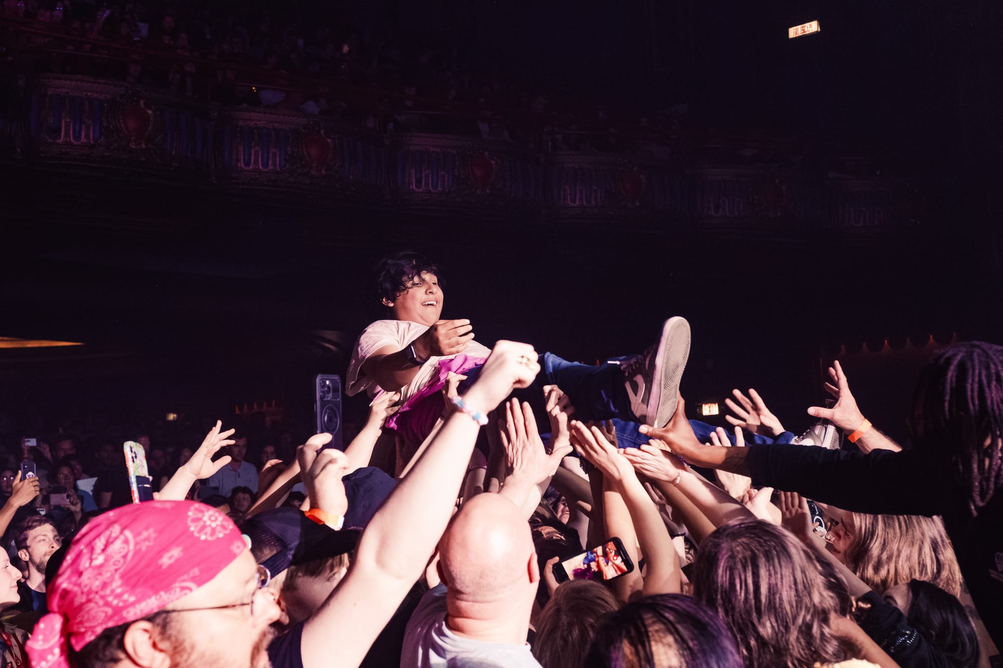 A young-looking person crowdsurfing.