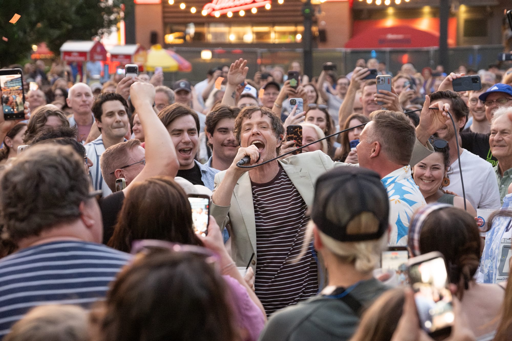 OK Go's lead singer performing in a sea of fans, all smiling and joyful.