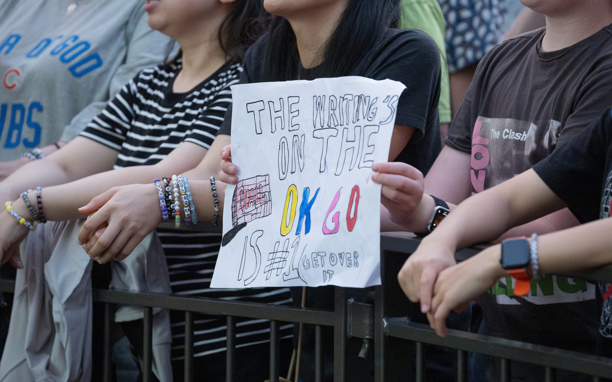 A fan sign saying "the writing's on the wall, OK Go is #1 (get over it).