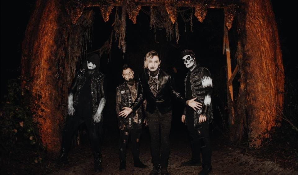 Group portrait of metalcore band Dark Divine in a forest at night